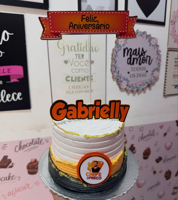 Bolo branco, laranja e preto com topo de Feliz Aniversário