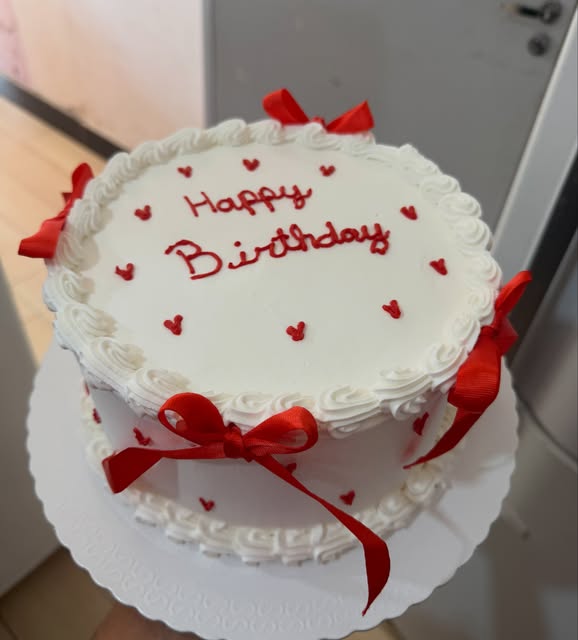 Bolo branco com laços vermelhos e Happy Birthday